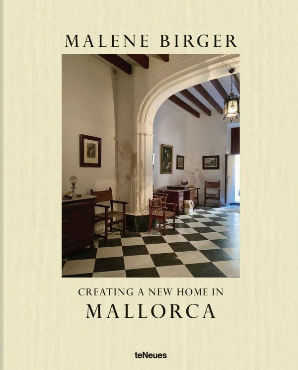 Book cover of Creating a New Home in Mallorca; featuring a hallway with a grand arch, and black and white floor tiles. Published by teNeues Books.