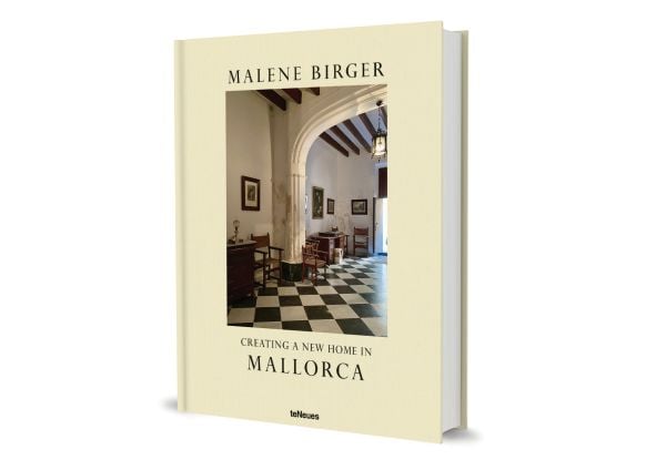 Book cover of Creating a New Home in Mallorca; featuring a hallway with a grand arch, and black and white floor tiles. Published by teNeues Books.