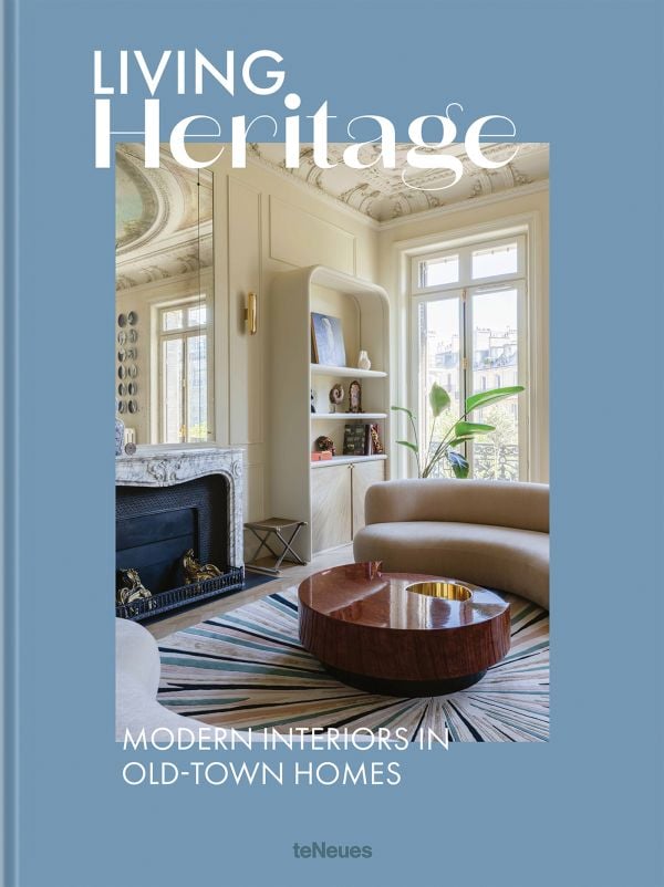 Book cover of Living Heritage: Modern Interiors in Old-Town Homes; with an interior living room with curved sofas and fireplace. Published by teNeues Books.