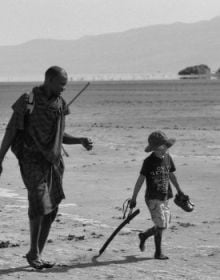 Book cover of Wonder and the World: A Childhood Among the Species, featuring a duotone photograph of a person looking at a large whale swimming near the sea's surface. Published by Verlag Kettler.