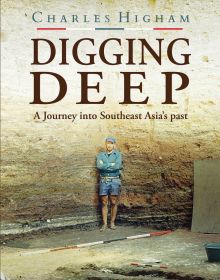 Book cover of Digging Deep: A Journey into Southeast Asia's past, with the British archaeologist in blue shirt and denim shorts, standing in excavated ground, high wall behind. Published by River Books.
