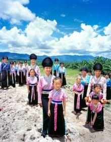 Book cover of Tai: A Woven Culture, with rice fields with workers in colourful clothes smiling at camera. Published by River Books.
