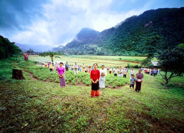 Book cover of Tai: A Woven Culture, with rice fields with workers in colourful clothes smiling at camera. Published by River Books.