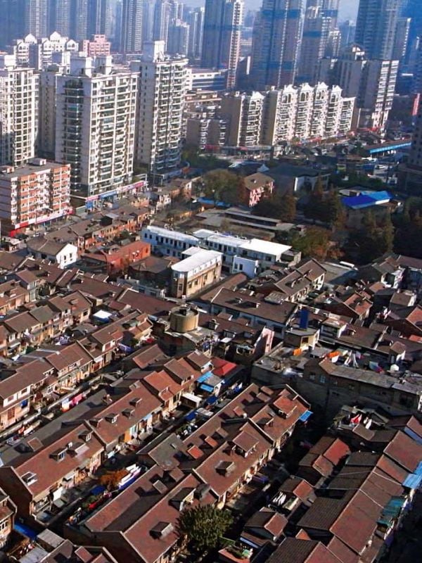 Book cover of Shanghai Shikumen, with a residential building, with trees to front. Published by Tongji University Press.
