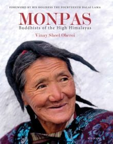 Head and shoulder shot of Monpa tribal woman gazing happily to her left in front of white wall, Monpas in large red font above