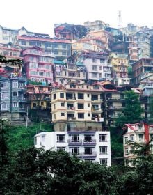 Breath taking photograph of white building complex up a mountainous landscape, Finding Shangri-La in orange font