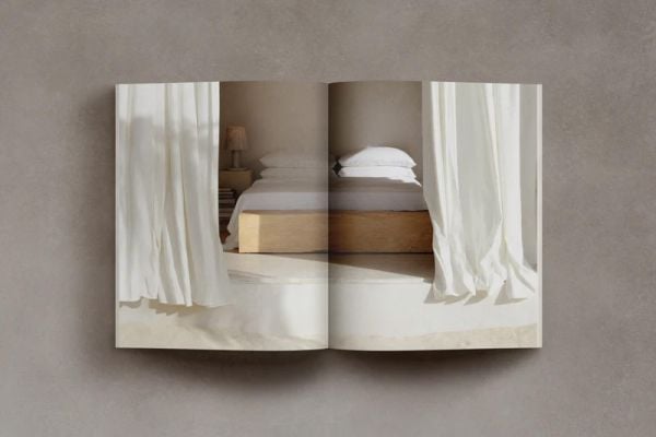 Book cover of Barefoot Living; featuring a rustic, minimalist interior with arch window and ceiling beams. Published by Helmin & Sorgenfri.