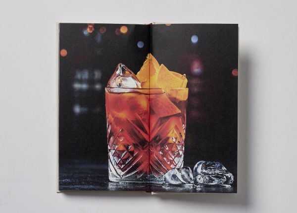 Book cover of Vermouth: A Classic Revival; featuring a cocktail, with an olive on a stick. Published by Helmin & Sorgenfri.
