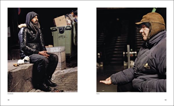 Book cover of Andres Serrano; with a homeless man laying under cardboard. Published by Silvana.