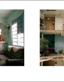 Front of old Cuban house, tropical green foliage growing up around door frame, CUBA VIVIR CON in gold font on blue banner above.