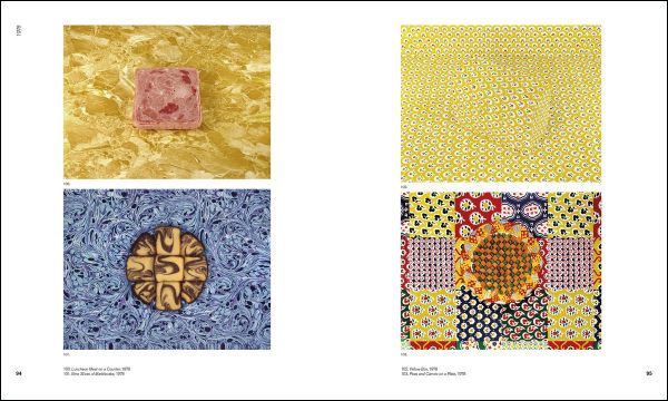 3 figures huddled in corner of blue fabric covered room, blue sculpture in foreground, white snowflakes, SANDY SKOGLUND in white font above