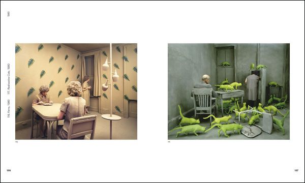 3 figures huddled in corner of blue fabric covered room, blue sculpture in foreground, white snowflakes, SANDY SKOGLUND in white font above