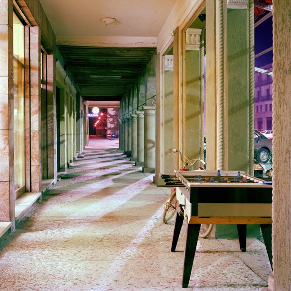 Pea green Fiat 500 with TV on top of roof, green trees behind, white cover, OLIVO BARBIERI EARLY WORKS 1980 1984 in black font above and below.