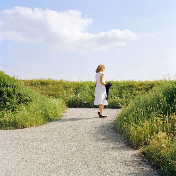 Pea green Fiat 500 with TV on top of roof, green trees behind, white cover, OLIVO BARBIERI EARLY WORKS 1980 1984 in black font above and below.