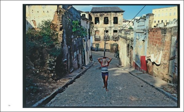 Book cover of Miguel Rio Branco, with a black female resting her hand on pool table, in dark lit room. Published by Silvana.