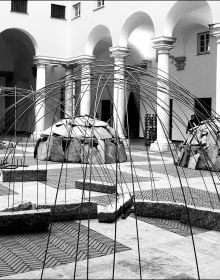 Blue filter photo of interior museum with Germano Celant The Story of (my) Exhibitions in blue and white font