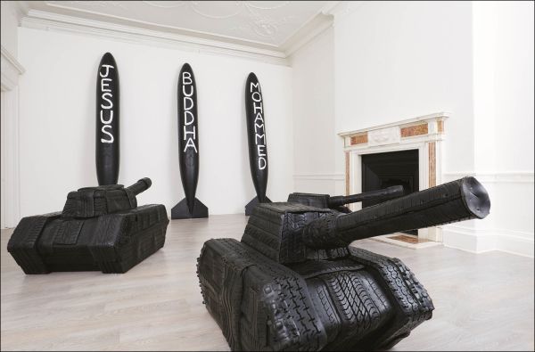 Book cover of Paolo Canevari: Self-Portrait; featuring an exhibition wall covered with small black figures with man in dark clothes walking past. Published by Silvana.