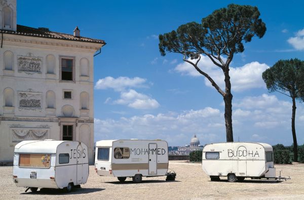 Book cover of Paolo Canevari: Self-Portrait; featuring an exhibition wall covered with small black figures with man in dark clothes walking past. Published by Silvana.
