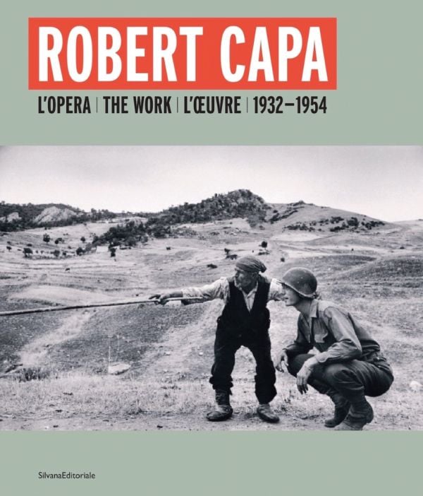 Book cover of Robert Capa, featuring a photo of a Sicilian man telling an American officer which way the Germans had gone, near Troina, Sicily, 1943. Published by Silvana.