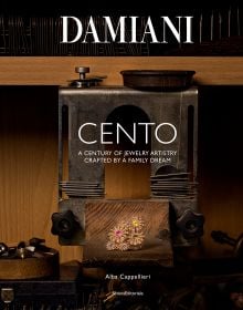 Book cover of Damiani: 100 X 100 Italiani, with the Mimosa Eternal Blue necklace with a sapphire from Sri Lanka surrounded by diamonds. Published by Silvana.