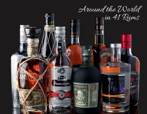 Book cover of The Spirit of Rum, History, Anecdotes, Trends and Cocktails, with a crystal glass of rum on large wooden die. Published by White Star.