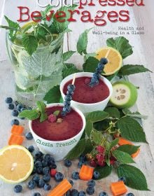 Book cover of Cold-Pressed Beverages, Health and Well-Being in a Glass, with dark red smoothies in white mugs with cocktail sticks of blueberries. Published by White Star.