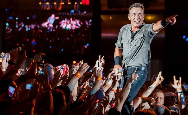 Book cover of Bruce Springsteen, 50 Years of Rock 'n' Roll, with the guitarist on stage at Brendan Byrne Arena, wearing red bandana. Published by White Star.