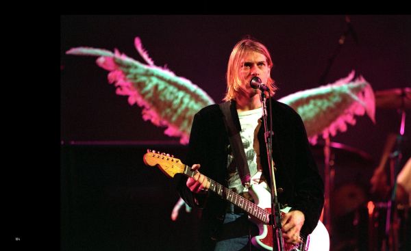 Book cover of Kurt Cobain: The Fallen Angel of Rock 'N' Roll, with an iconic image of the singer wearing thick, black eyeliner, staring into the camera. Published by White Star.
