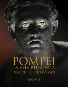 Book cover of Pompeii: A Life Revealed, featuring a bronze head with mouth open, and bright yellowing eyes. Published Scripta Maneant Editori.