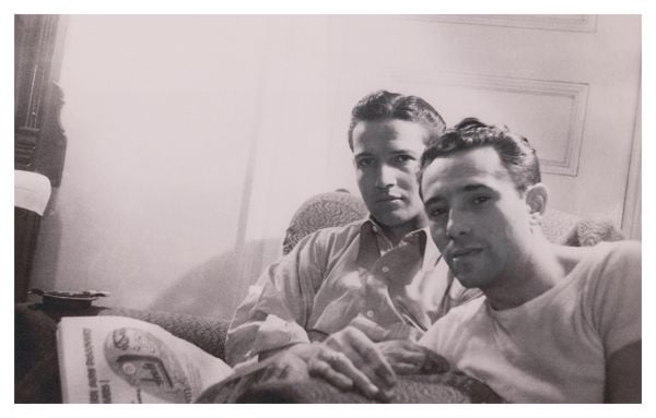 Book cover of Loving II: More photographic history of men in love, 1850s - 1950s; featuring a male couple holding up a sigh saying 'Not married but willing to be'. Published by 5 Continents Editions.