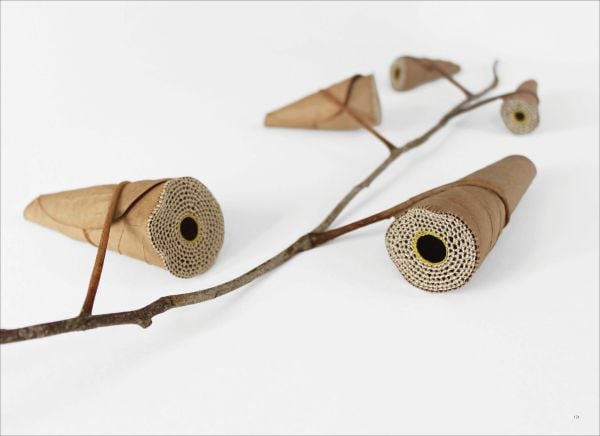 Book cover of art monograph Susanna Bauer, with brown leaf with white circle of beads embroidered to centre. Published by 5 Continents Editions.