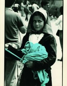 Book cover of Legarsi alla Montagna, Binding to the mountain, featuring a woman in black, stretching out a long blue ribbon through a street. Published by 5 Continents Editions.