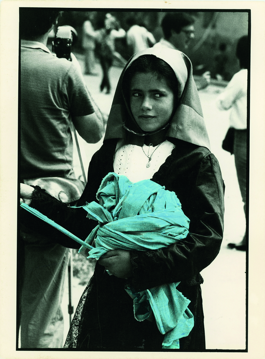 Book cover of Legarsi alla Montagna, Binding to the mountain, featuring a woman in black, stretching out a long blue ribbon through a street. Published by 5 Continents Editions.