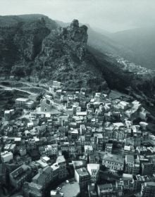 Book cover of Legarsi alla Montagna, Binding to the mountain, featuring a woman in black, stretching out a long blue ribbon through a street. Published by 5 Continents Editions.