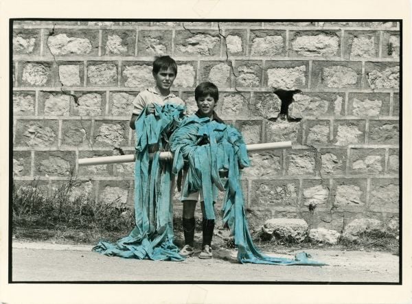 Book cover of Legarsi alla Montagna, Binding to the mountain, featuring a woman in black, stretching out a long blue ribbon through a street. Published by 5 Continents Editions.