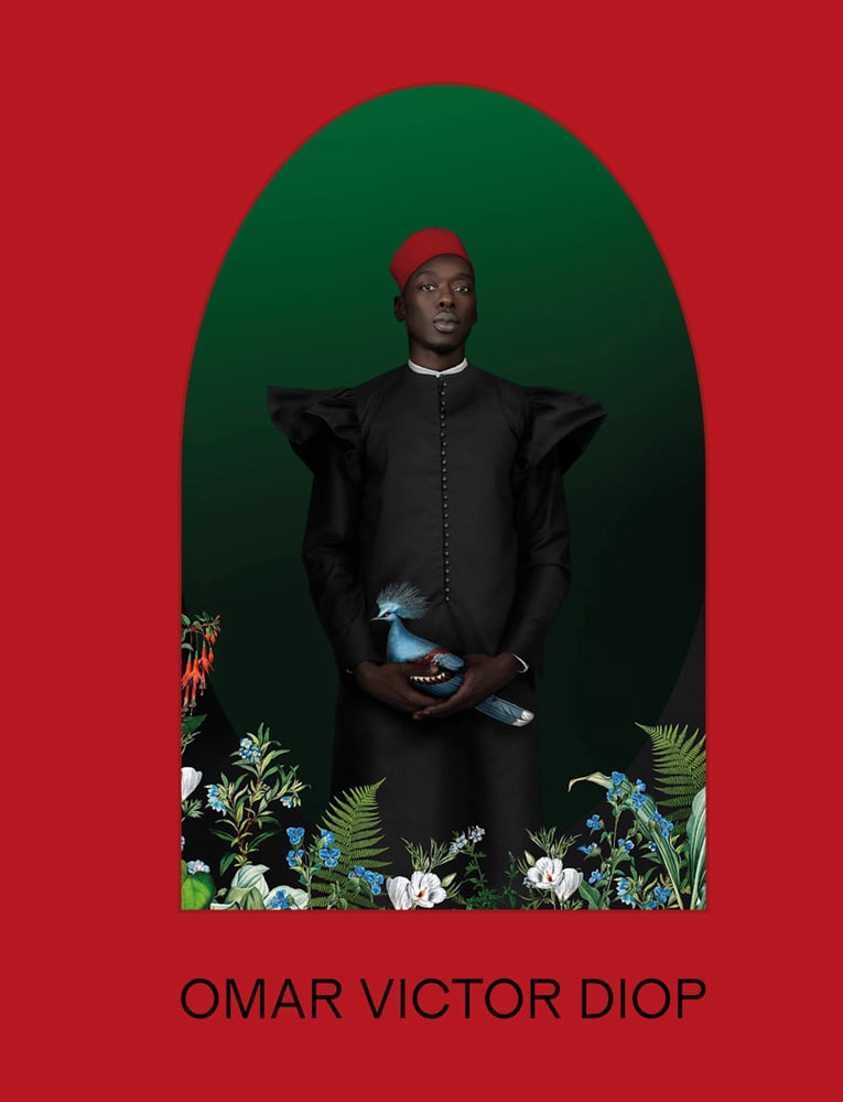 Portrait of black man in black smock and red hat, holding blue exotic bird, with red arched border and Omar Victor Diop in black font below