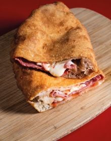 Book cover of La Pizza: Con i migliori salumi i d'italia, with a slice of pizza and a piece of salami. Published by Manfredi Edizioni.