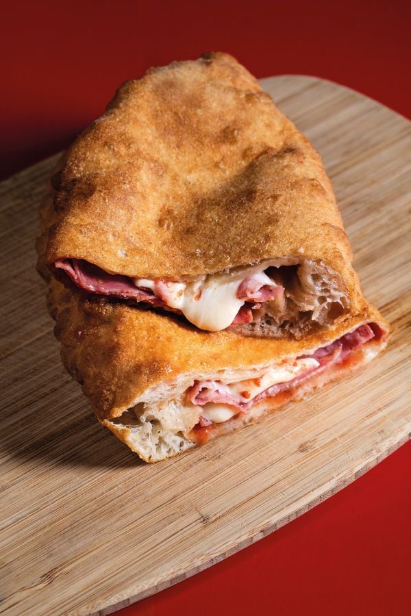 Book cover of La Pizza: Con i migliori salumi i d'italia, with a slice of pizza and a piece of salami. Published by Manfredi Edizioni.