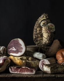 Book cover of Sabatino Sorrentino's La Merenda Italiana: con i migliori salumi d'Italia, with a pastry parcel topped with prosciutto and cheese. Published by Manfredi Edizioni.
