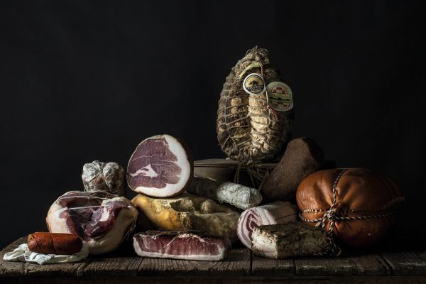 Book cover of Sabatino Sorrentino's La Merenda Italiana: con i migliori salumi d'Italia, with a pastry parcel topped with prosciutto and cheese. Published by Manfredi Edizioni.