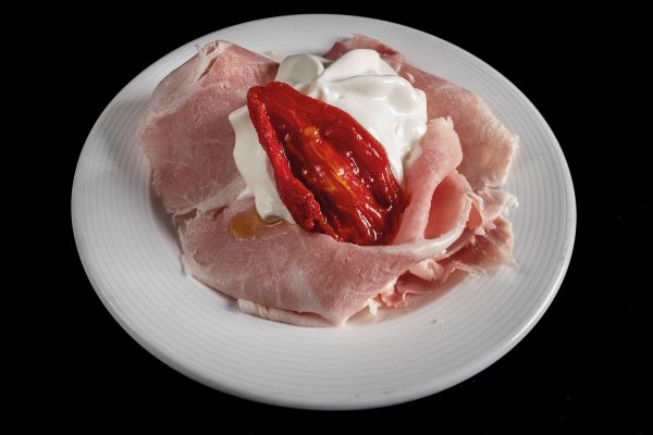 Book cover of Sabatino Sorrentino's La Merenda Italiana: con i migliori salumi d'Italia, with a pastry parcel topped with prosciutto and cheese. Published by Manfredi Edizioni.