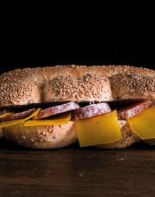 Book cover of Sabatino Sorrentino's La Merenda Italiana: con i migliori salumi d'Italia, with a pastry parcel topped with prosciutto and cheese. Published by Manfredi Edizioni.