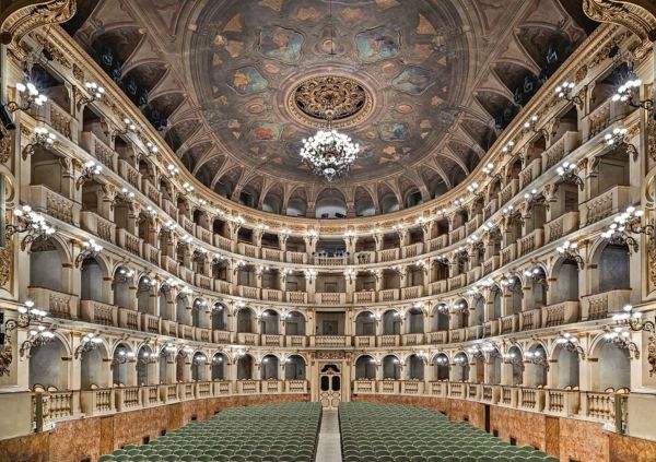 Grand interior of ceiling and seating area of Teatro Comunale di Bologna, Teatro Comunale di Bologna – The Comunale Theatre in Bologna in gold font above and below.