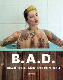White tattooed model sitting in bathtub, on cover of 'B.A.D. Beautiful And Determined', by Drago.