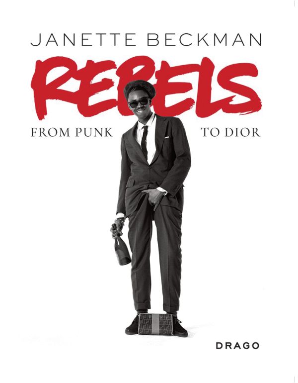 Book cover of Rebels: From Punk to Dior, featuring Slick Rick, posing with one hand grabbing crotch, the other holding champagne bottle. Published by Drago.