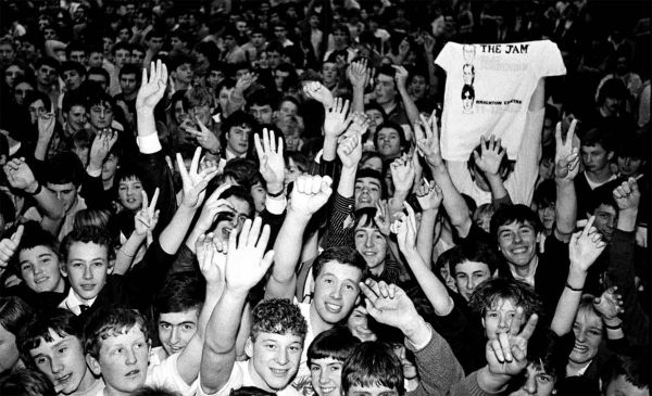 Book cover of Rebels: From Punk to Dior, featuring Slick Rick, posing with one hand grabbing crotch, the other holding champagne bottle. Published by Drago.