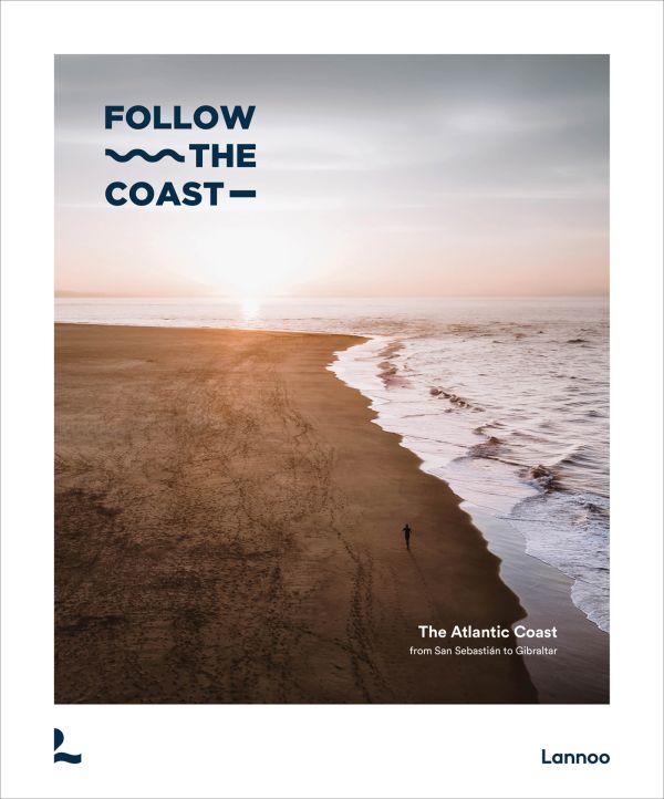 Book cover of Follow the Coast – from San Sebastián to Gibraltar: A Visual Travel Guide of the Atlantic Coast, featuring an aerial beach view. Published by Lannoo Publishers.