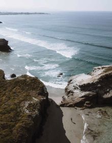 Book cover of Follow the Coast – from San Sebastián to Gibraltar: A Visual Travel Guide of the Atlantic Coast, featuring an aerial beach view. Published by Lannoo Publishers.