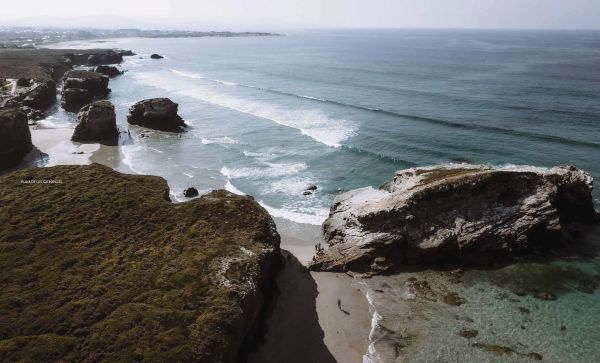 Book cover of Follow the Coast – from San Sebastián to Gibraltar: A Visual Travel Guide of the Atlantic Coast, featuring an aerial beach view. Published by Lannoo Publishers.