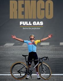 Book cover of Remco Evenepoel Full Gas: Strive for perfection, featuring the Belgian cyclist with his arms outstretched to the sky, his bike in front. Published by Lannoo Publishers.